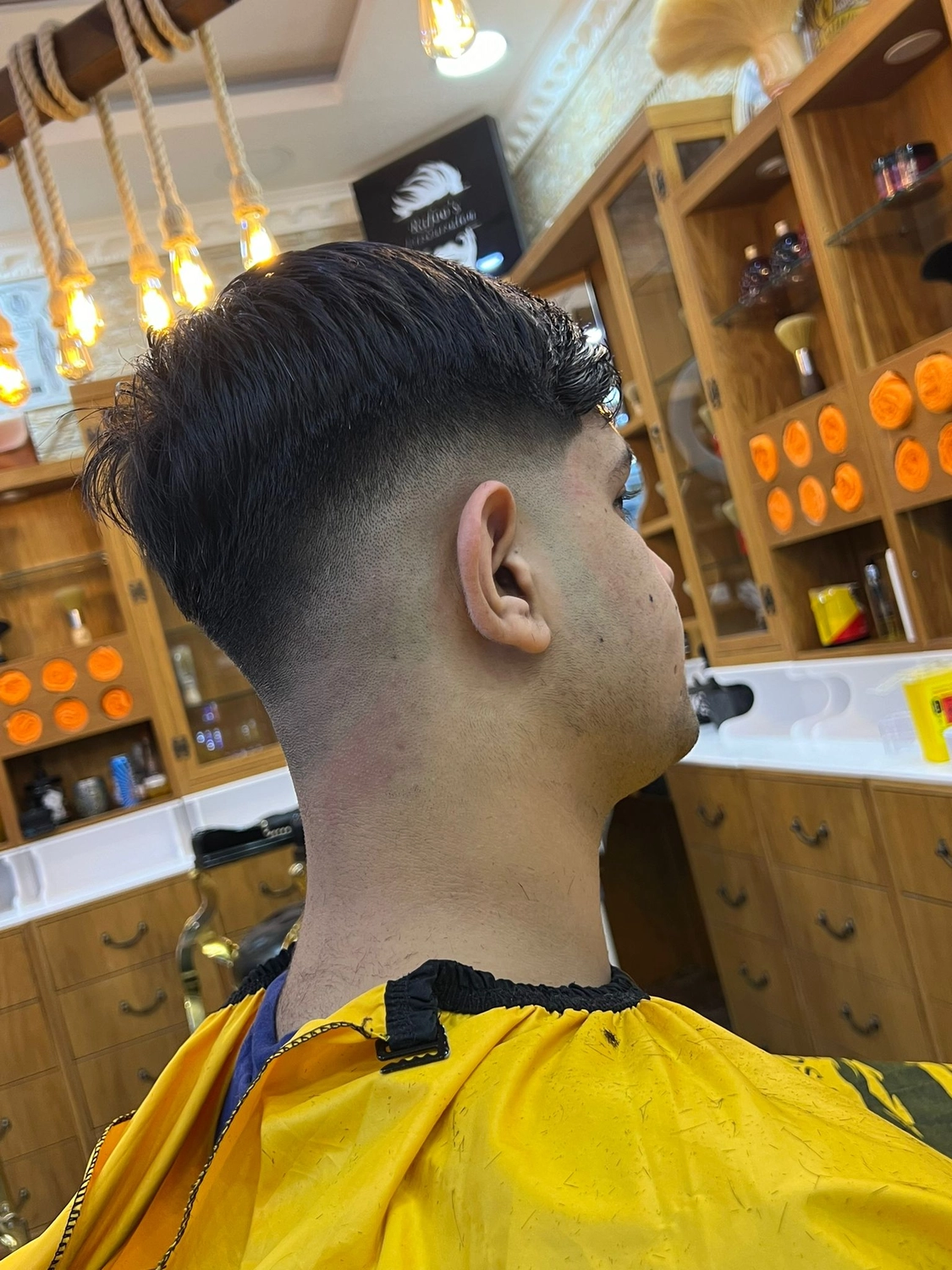 El barbero MB - Haar- und Hautpflegebehandlungen - Seitenansicht eines Jungen mit neuem Haarschnitt im Friseursalon.