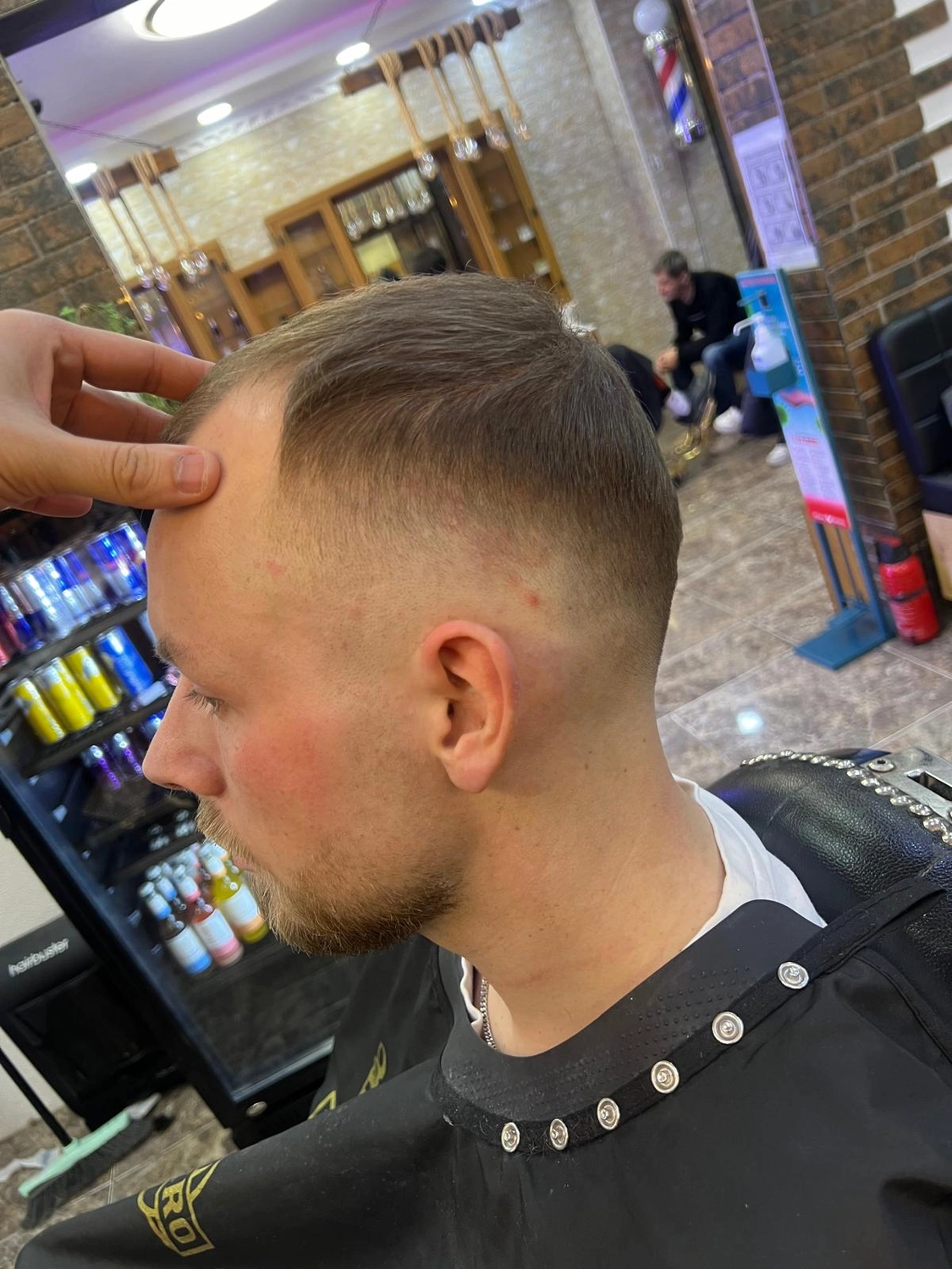 El barbero MB - Haar- und Hautpflegebehandlungen - Seitenansicht eines Jungen mit neuem Haarschnitt im Friseursalon.